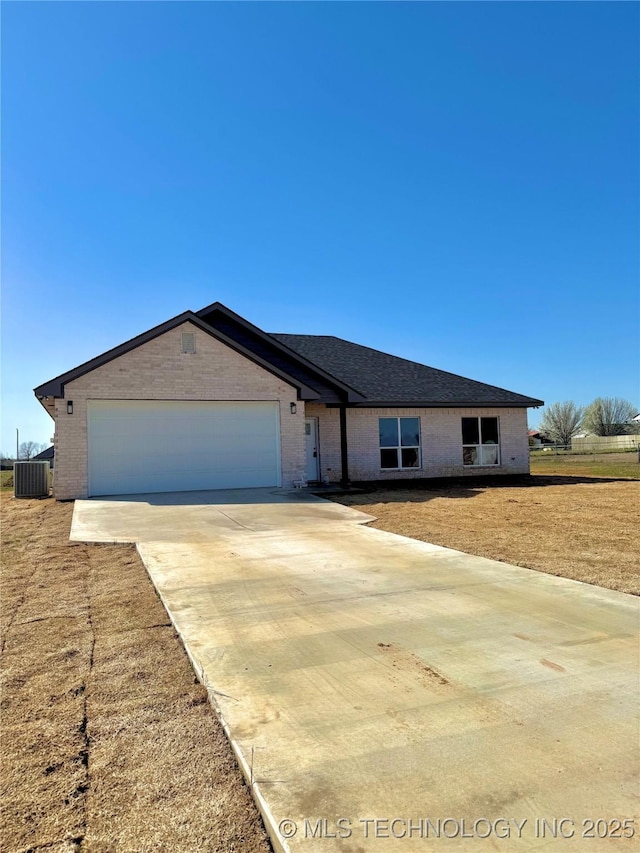 ranch-style home with central air condition unit, brick siding, concrete driveway, and an attached garage