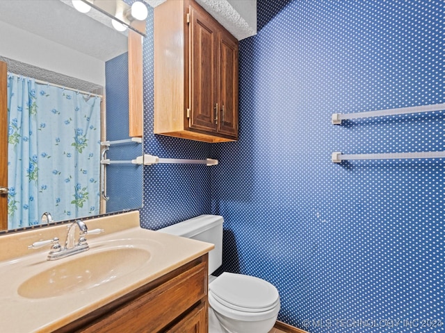 bathroom with a shower with shower curtain, vanity, and toilet