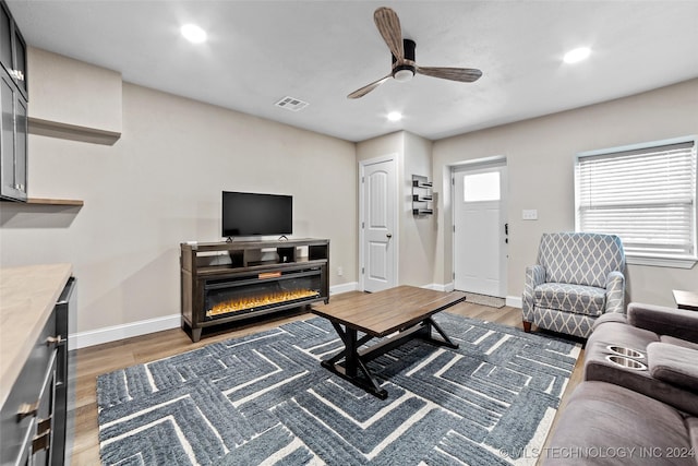 living room with ceiling fan and dark hardwood / wood-style flooring