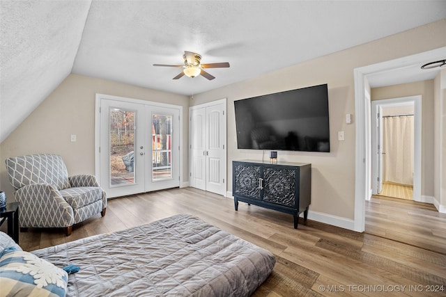 living room with hardwood / wood-style flooring, ceiling fan, lofted ceiling, and a textured ceiling