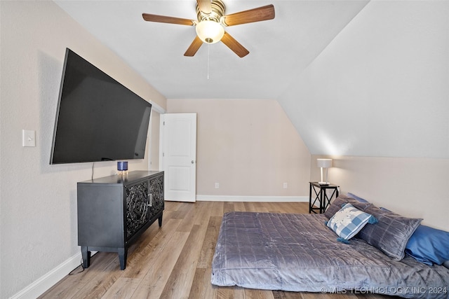 bedroom with ceiling fan, light hardwood / wood-style floors, and vaulted ceiling