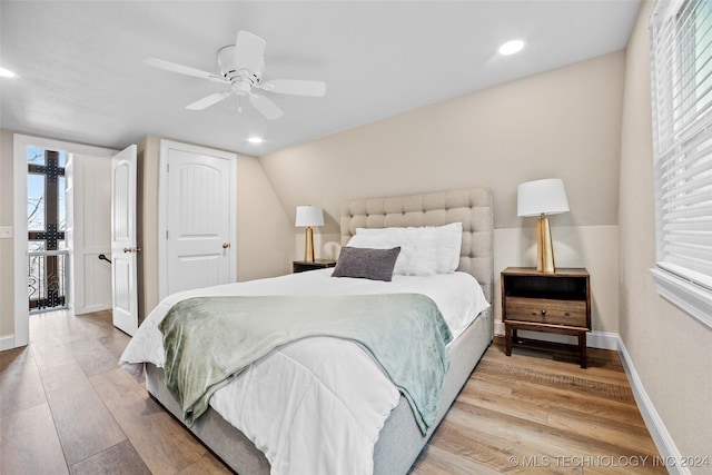 bedroom with multiple windows, ceiling fan, and light hardwood / wood-style floors