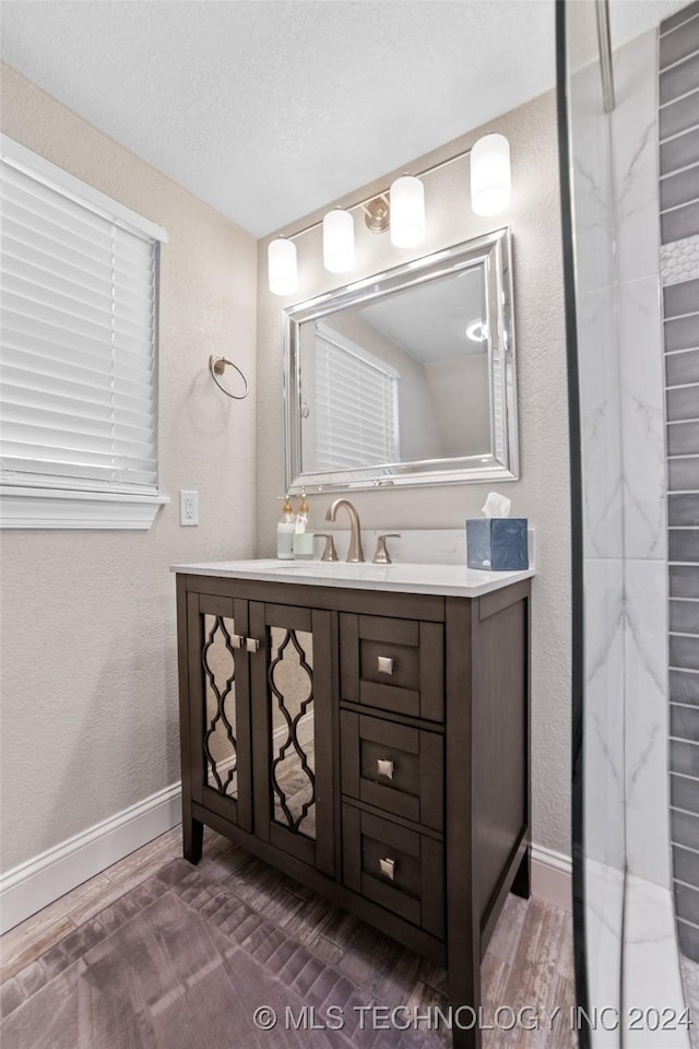 bathroom featuring hardwood / wood-style floors, vanity, and a textured ceiling