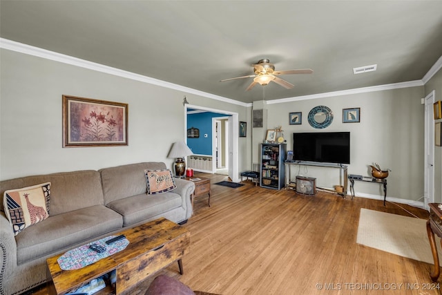 living room featuring crown molding, ceiling fan, and light wood-type flooring