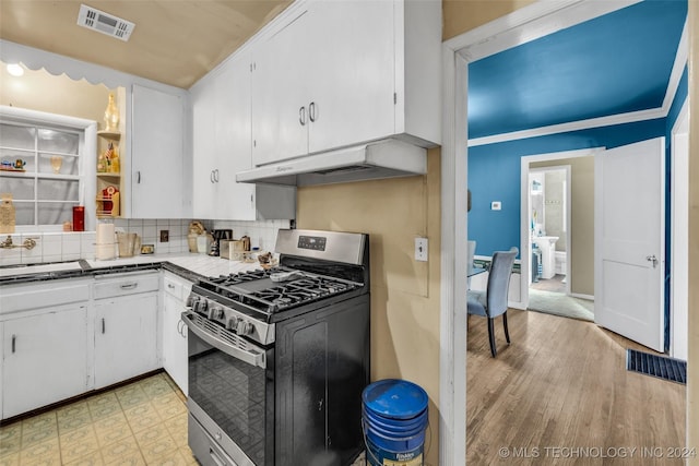 kitchen featuring ventilation hood, sink, light hardwood / wood-style flooring, gas range, and white cabinetry