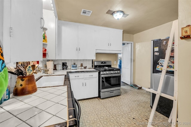 kitchen featuring white cabinets, decorative backsplash, stainless steel appliances, and sink