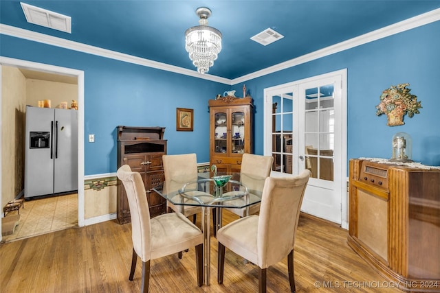 dining room with crown molding, french doors, a chandelier, and hardwood / wood-style flooring