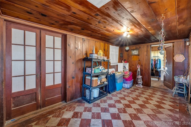 basement with wood walls, french doors, and wooden ceiling