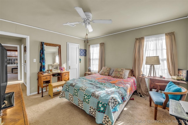 carpeted bedroom featuring multiple windows and ceiling fan