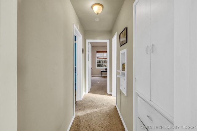 hall with light colored carpet