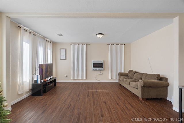 living room featuring heating unit and dark hardwood / wood-style floors