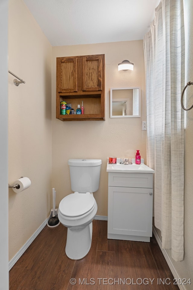 bathroom with hardwood / wood-style floors, vanity, and toilet