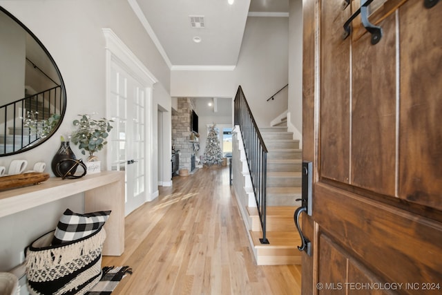 entrance foyer featuring ornamental molding and light hardwood / wood-style flooring