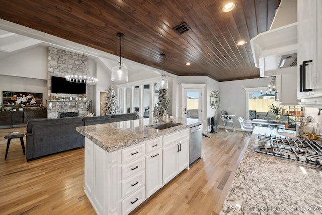 kitchen featuring pendant lighting, a kitchen island with sink, white cabinets, sink, and stainless steel appliances