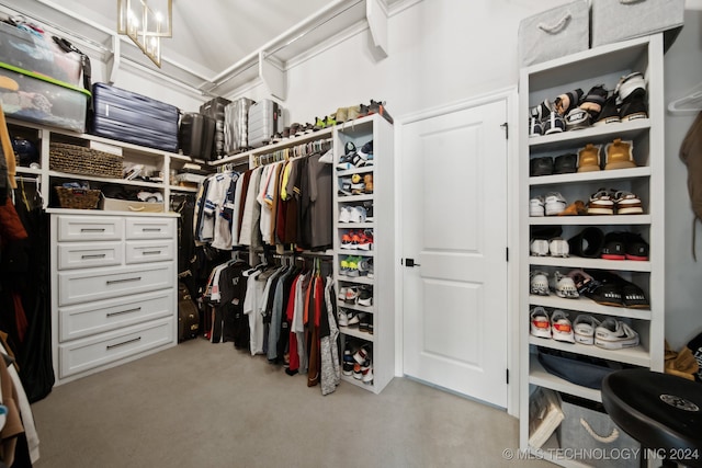 walk in closet with light carpet and a chandelier