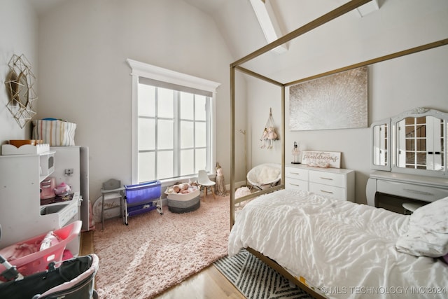 bedroom with hardwood / wood-style floors and vaulted ceiling with beams