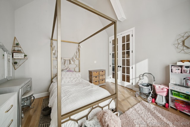 bedroom featuring vaulted ceiling, light wood-type flooring, and french doors