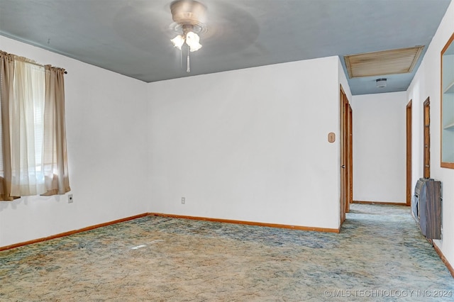 empty room featuring heating unit, light carpet, radiator heating unit, and ceiling fan