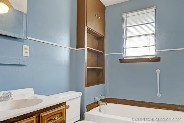 bathroom featuring a washtub, vanity, and toilet