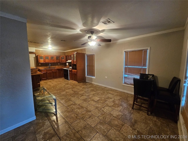 kitchen with a textured ceiling, ceiling fan, crown molding, sink, and stainless steel range oven