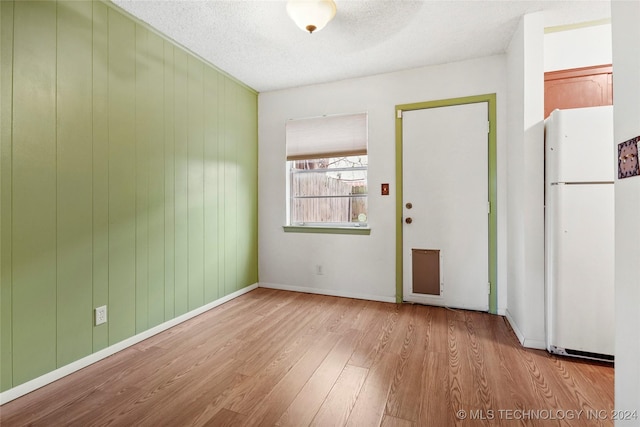 unfurnished room featuring light hardwood / wood-style flooring and a textured ceiling