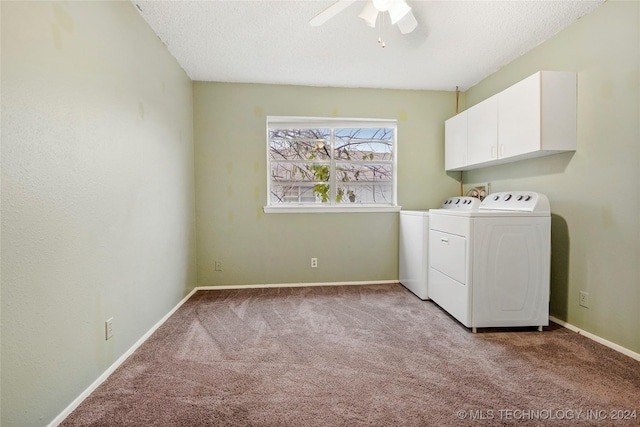 laundry area featuring washer and clothes dryer, cabinets, light carpet, ceiling fan, and a textured ceiling