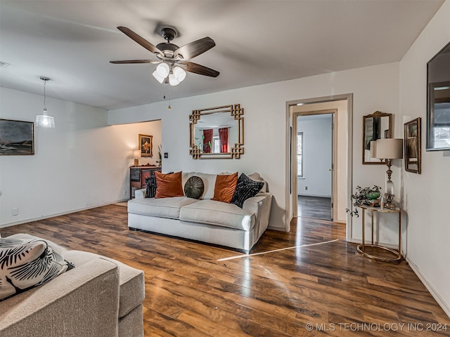 living room with ceiling fan and dark wood-type flooring