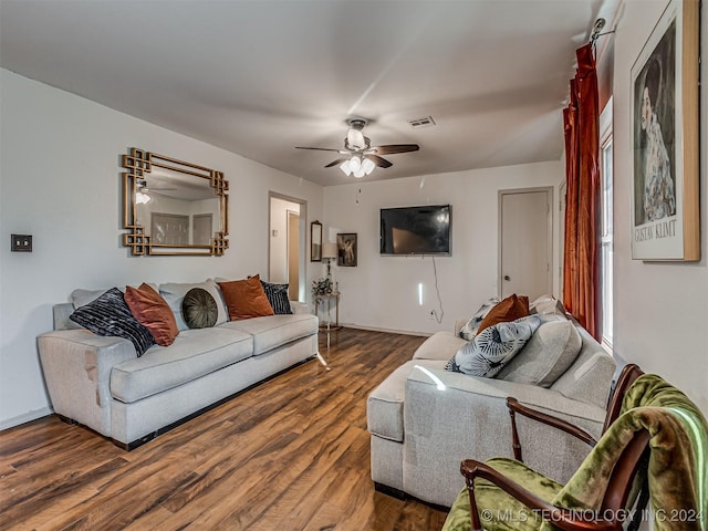 living room featuring ceiling fan and dark wood-type flooring