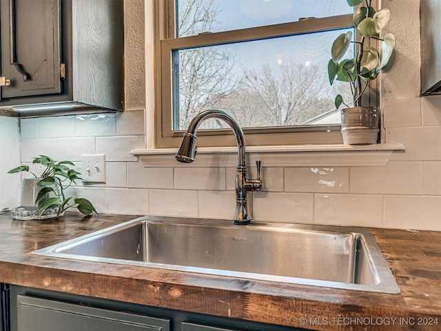 details with tasteful backsplash, dishwasher, and sink