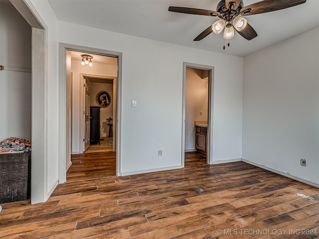 unfurnished bedroom with ceiling fan and dark wood-type flooring