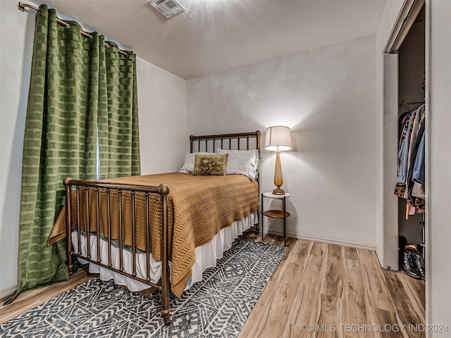 bedroom with hardwood / wood-style floors and a closet