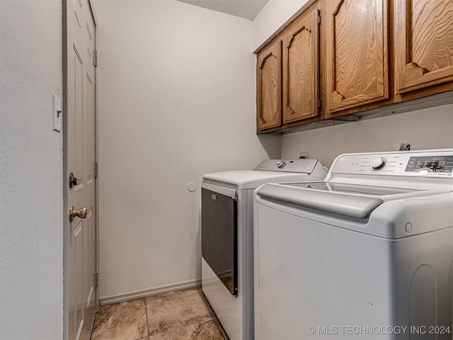 laundry room with washer and dryer and cabinets