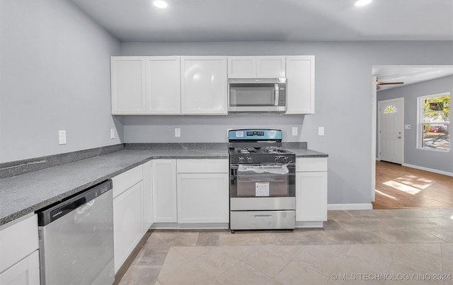 kitchen featuring stainless steel appliances, white cabinetry, ceiling fan, and light hardwood / wood-style floors