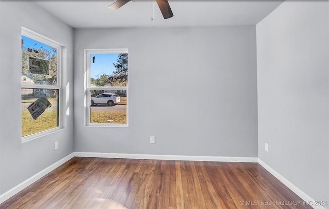 empty room with ceiling fan and dark hardwood / wood-style flooring