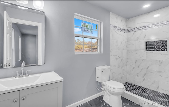 bathroom featuring tile patterned floors, vanity, toilet, and a tile shower