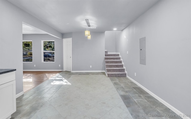 interior space featuring electric panel and light hardwood / wood-style flooring