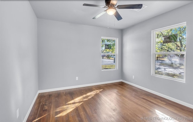 empty room with ceiling fan and hardwood / wood-style flooring