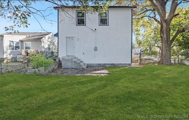 rear view of property with a yard