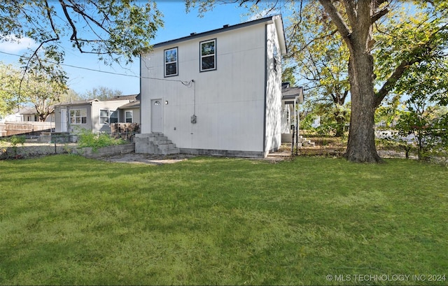 back of house featuring a lawn