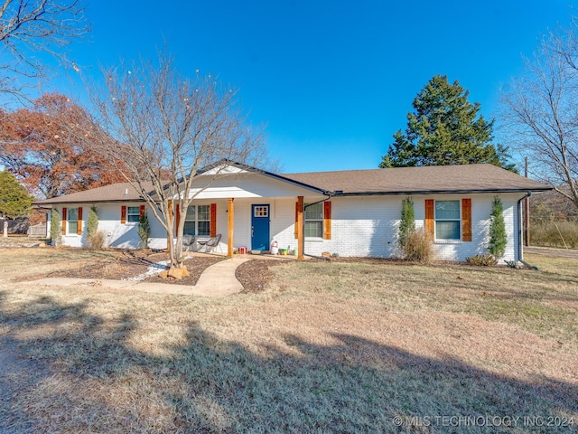 ranch-style house with covered porch and a front lawn