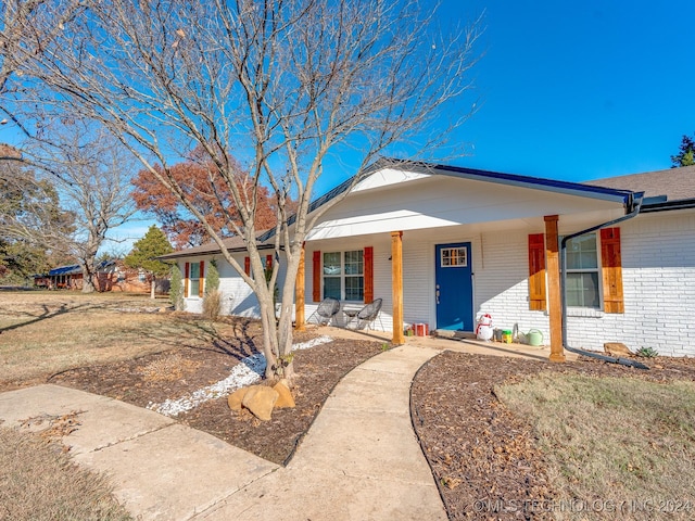 single story home featuring a front lawn and covered porch