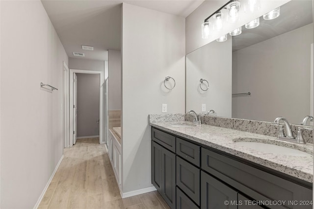 bathroom featuring vanity, hardwood / wood-style flooring, and a bathing tub