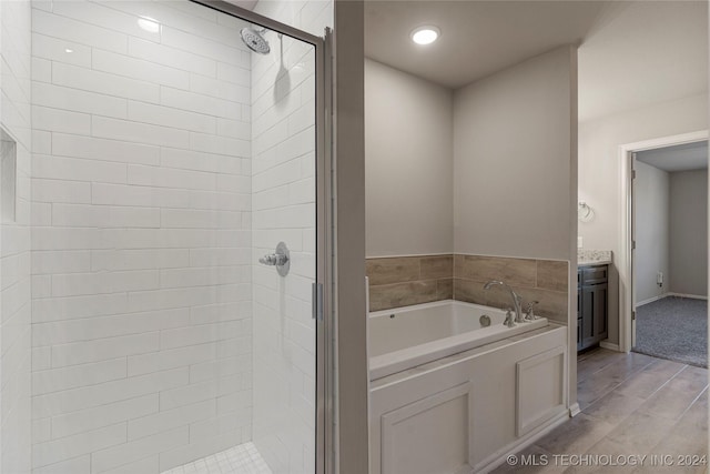 bathroom featuring hardwood / wood-style floors, vanity, and shower with separate bathtub