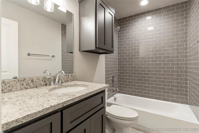 full bathroom with vanity, tiled shower / bath combo, and toilet