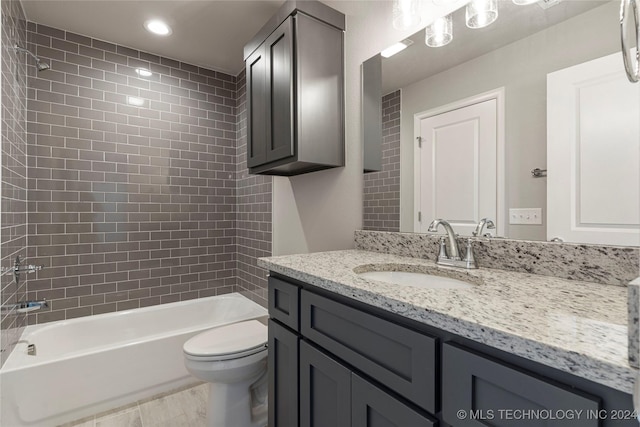 full bathroom with toilet, vanity, and tiled shower / bath