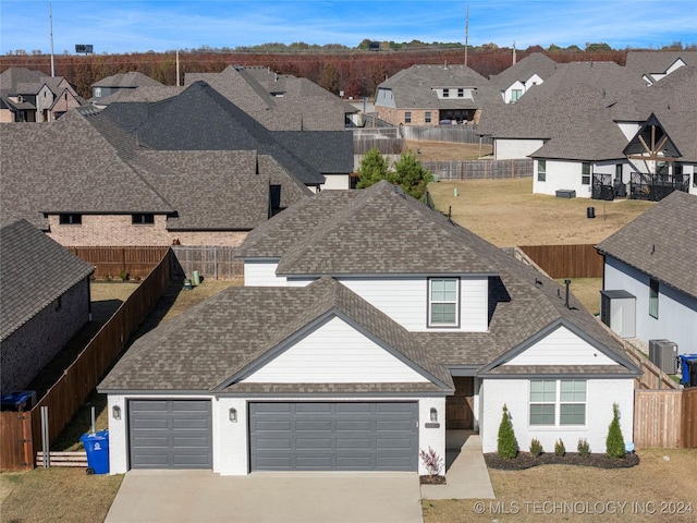 view of front of property featuring cooling unit and a garage