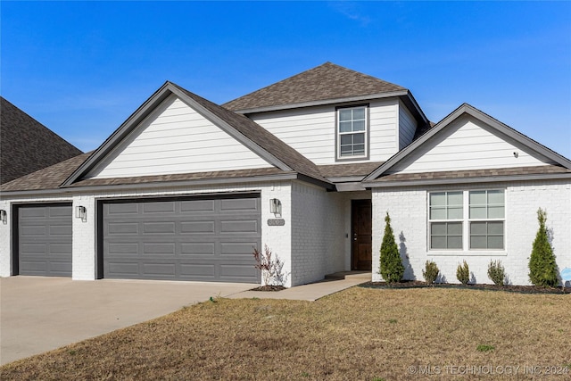 view of front of home with a front yard and a garage