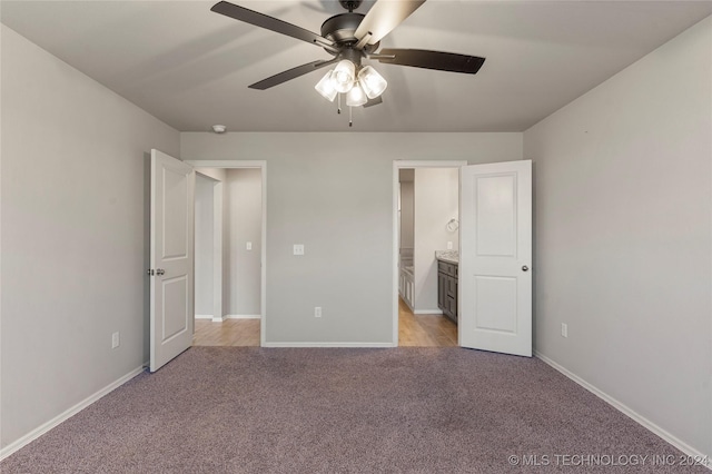 unfurnished bedroom with connected bathroom, light colored carpet, and ceiling fan