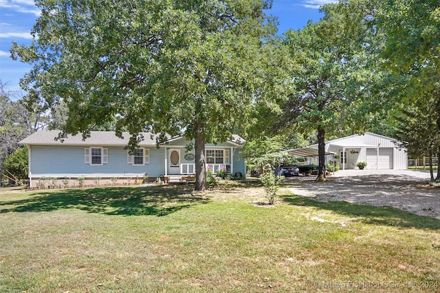 ranch-style home featuring a carport, a garage, covered porch, and a front yard