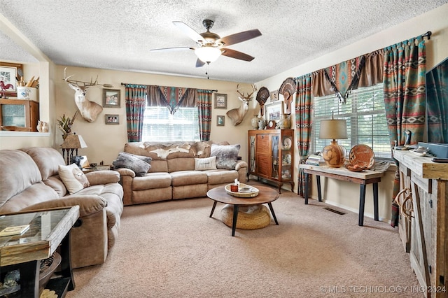 carpeted living room featuring ceiling fan and a textured ceiling